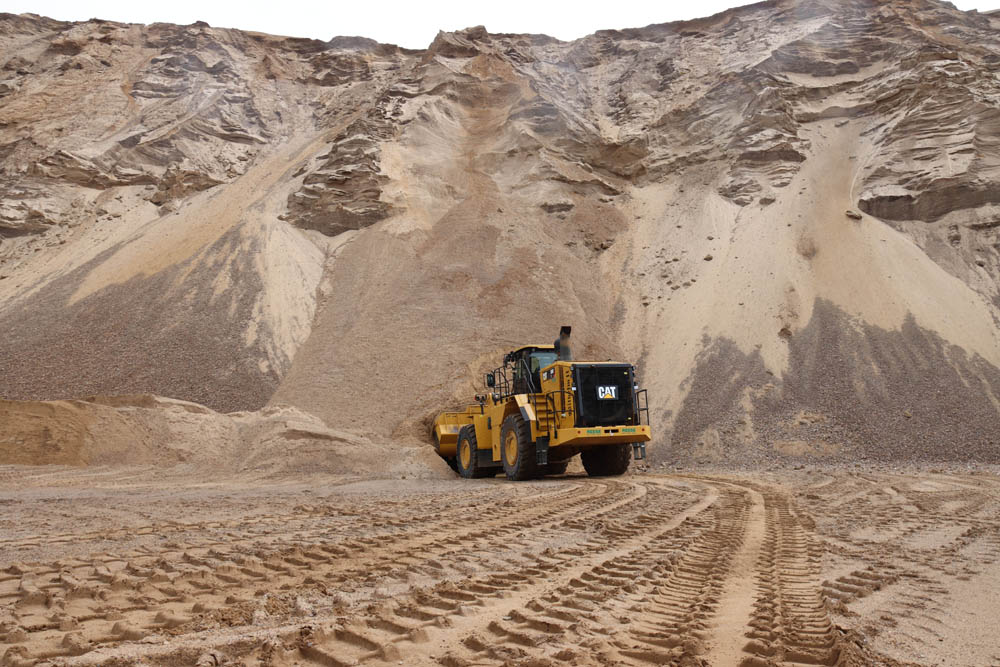 A Cat 988K wheeled loader digging into a quarry stockpile