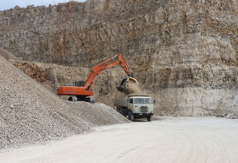 An MB Crusher excavator bucket is being used in Italy to prepare clean crushed rocks to be laid for new rail tracks, all done reusing available materials