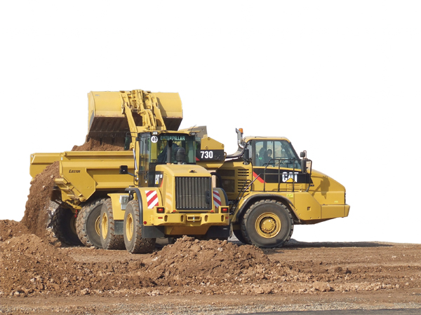 Wheeled loader filling up a dump truck with soil