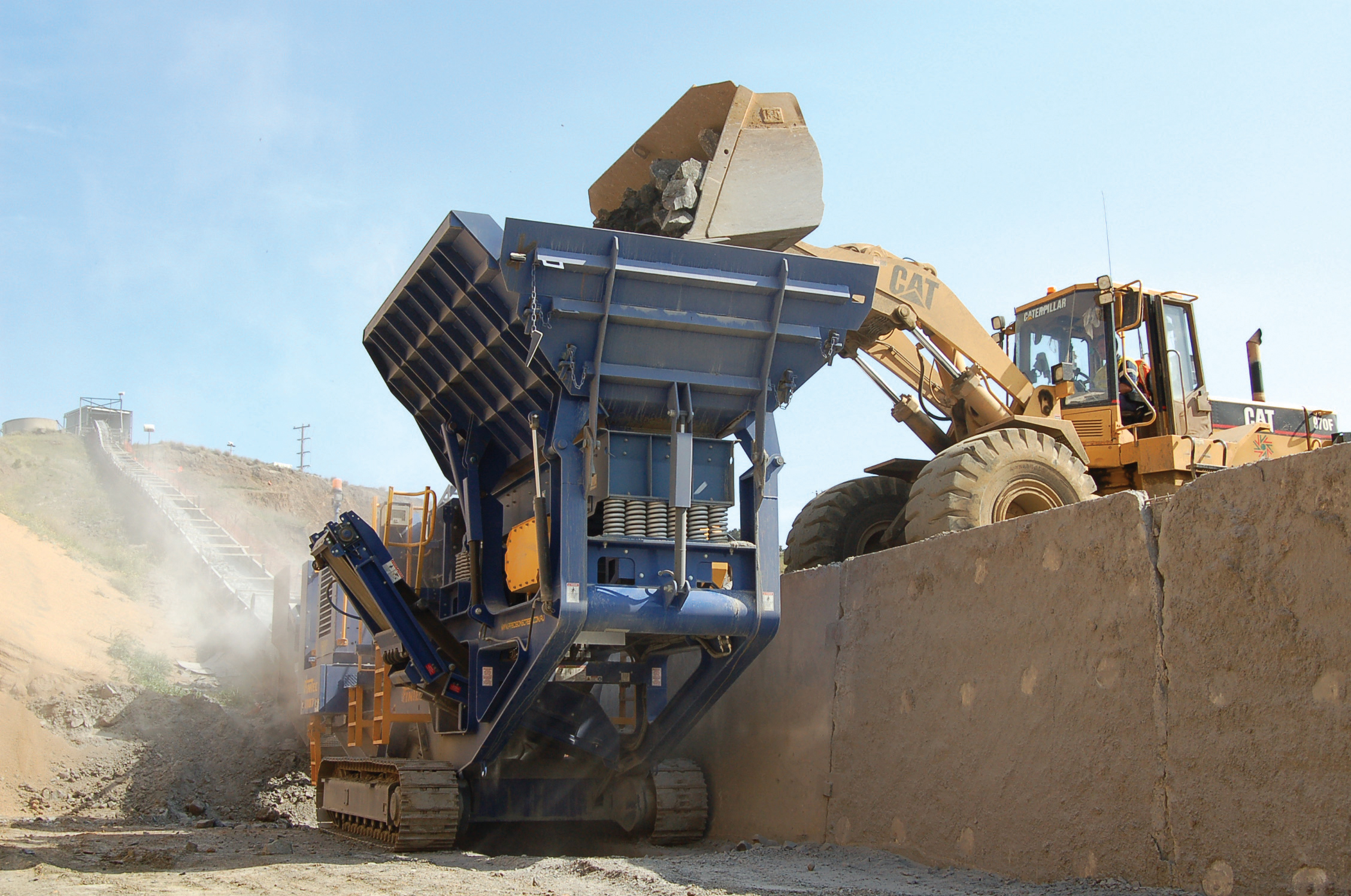 Cat loader putting minerals into a sandvik QJ330 jaw crusher