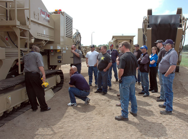 Dealers crowding round a machine during an in-depth training session