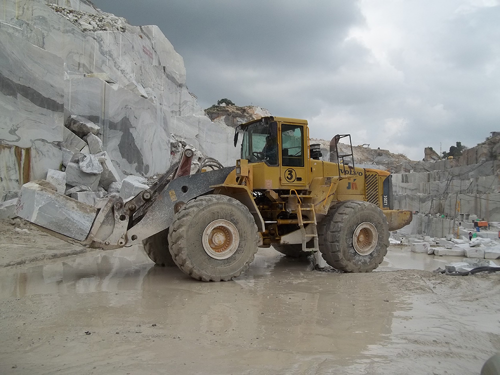 A Volvo wheeled loader handling marble blocks at a JK Natural Marbles site