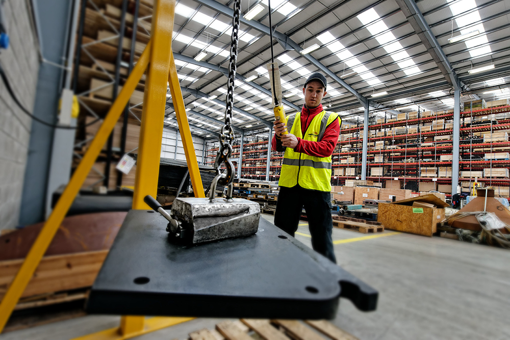 A magnet lifting a wear plate. The use of a magnet to move certain wear parts is an example of the health and safety emphasis at Terex’s state-of-the-art parts facility