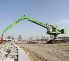 A Sennebogen 880 EQ  positions stone blocks for coastal fortifications on the La Mer project in Dubai.JPG