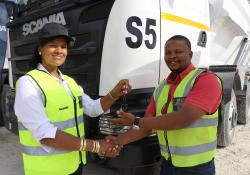 Charnie-Lee Adams-Kruger (left), hands over the keys to Amos Mabetha of PPC Cement.JPG