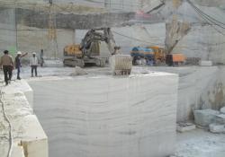 Volvo excavator being used by JK Natural Mables to push a large marble block away from the bench650.jpg