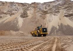 A Cat 988K wheeled loader digging into a quarry stockpile