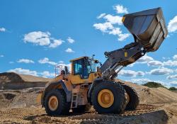 A Volvo wheeled loader loading material onto a truck at an AS Silikaat sand mine pit