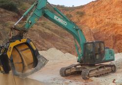 An MB Crusher MB-S18 screening bucket attached to a Kobelco SK220SD excavator screening sandstone in an Indian quarry