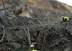 workers pumping water from hole