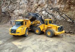 a volvo wheeled loader depositing into a volvo truck