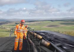 Two workmen inspecting a conveyor belt