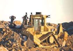 Cat D11T bull dozes rubble in quarry 