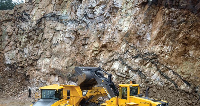 a volvo wheeled loader depositing into a volvo truck