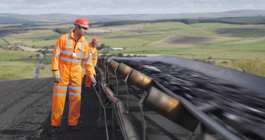 Two workmen inspecting a conveyor belt