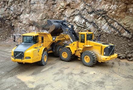 a volvo wheeled loader depositing into a volvo truck