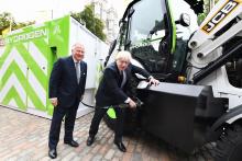  Boris Johnson refuels the prototype hydrogen-powered backhoe loader, watched by JCB chairman Lord Bamford