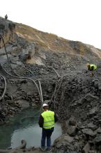 workers pumping water from hole