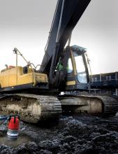 Excavator driving through mud 