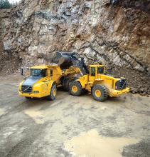 a volvo wheeled loader depositing into a volvo truck