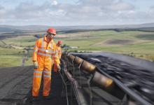 Two workmen inspecting a conveyor belt