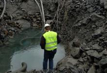 workers pumping water from hole