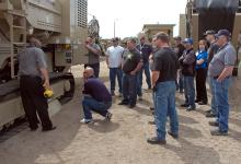 Dealers crowding round a machine during an in-depth training session