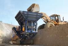 Cat loader putting minerals into a sandvik QJ330 jaw crusher