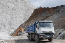 A Case excavator loads material onto a truck 