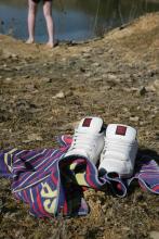 trainers, towel and feet on quarry pool 